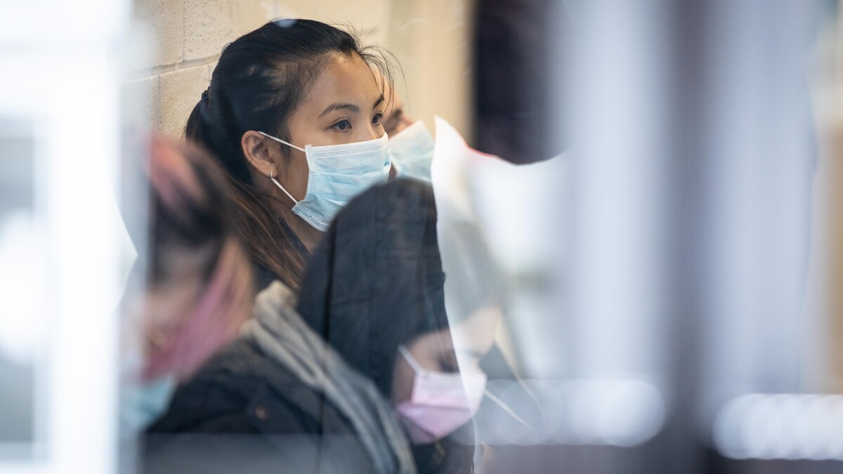 Des gens portent un masque et attendent dans une clinique. 