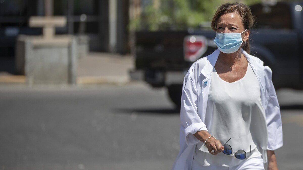 Une femme portant un masque de protection marche dans la rue.