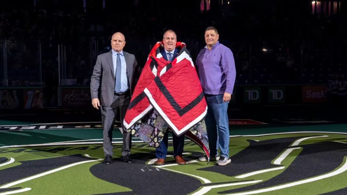 Mark Arcand et Derek Keenan enveloppent Pat Coyle dans une couverture.