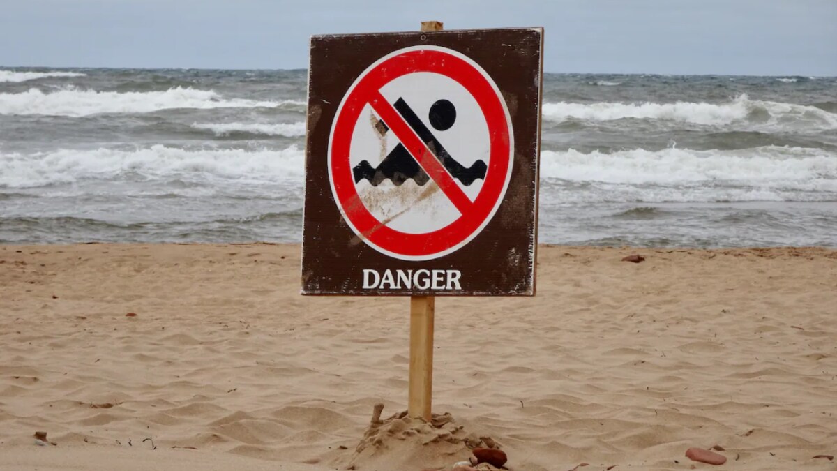 Une enseigne sur la plage indique le danger des courants.