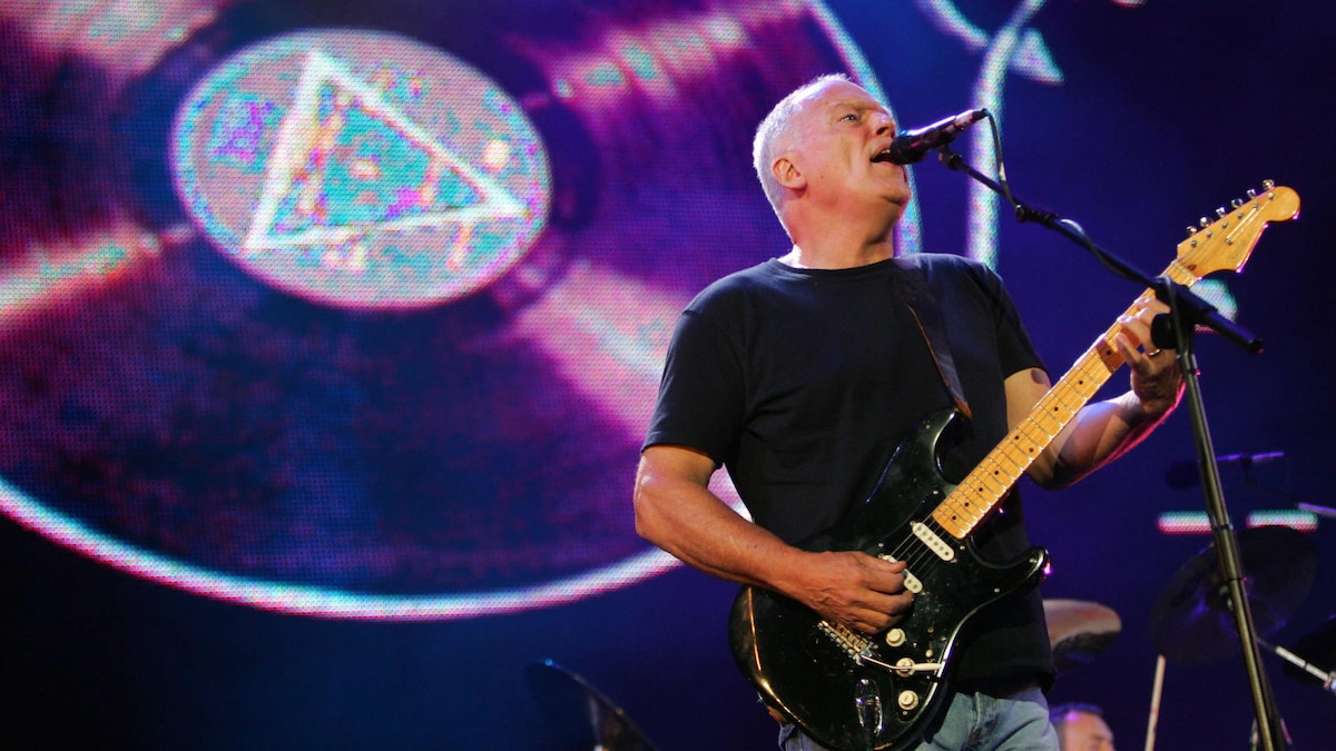 Gilmour joue de la guitare devant l'image d'un disque de vinyle.