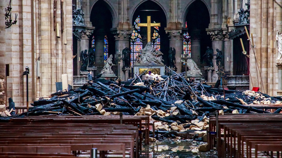 Plusieurs débris, dont des poutres en bois brûlées, reposent par terre après l'incendie qui a ravagé la cathédrale de Notre-Dame de Paris.