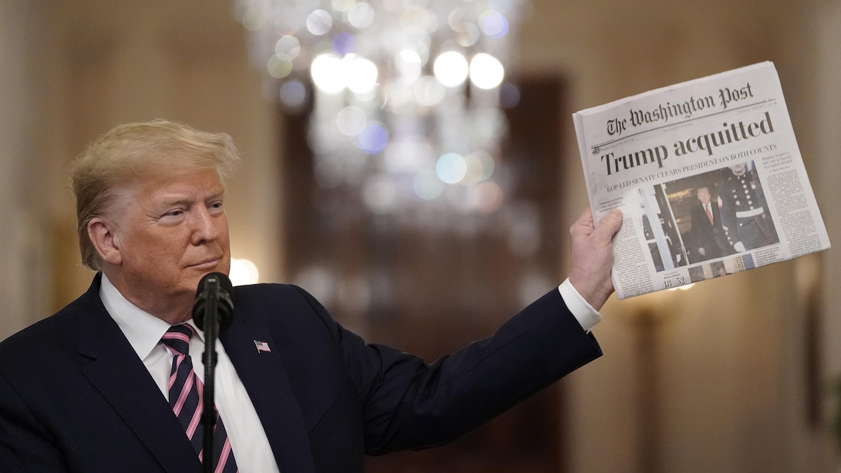 Plan serré sur Donald Trump brandi une copie du Washington Post à la Maison-Blanche. 
