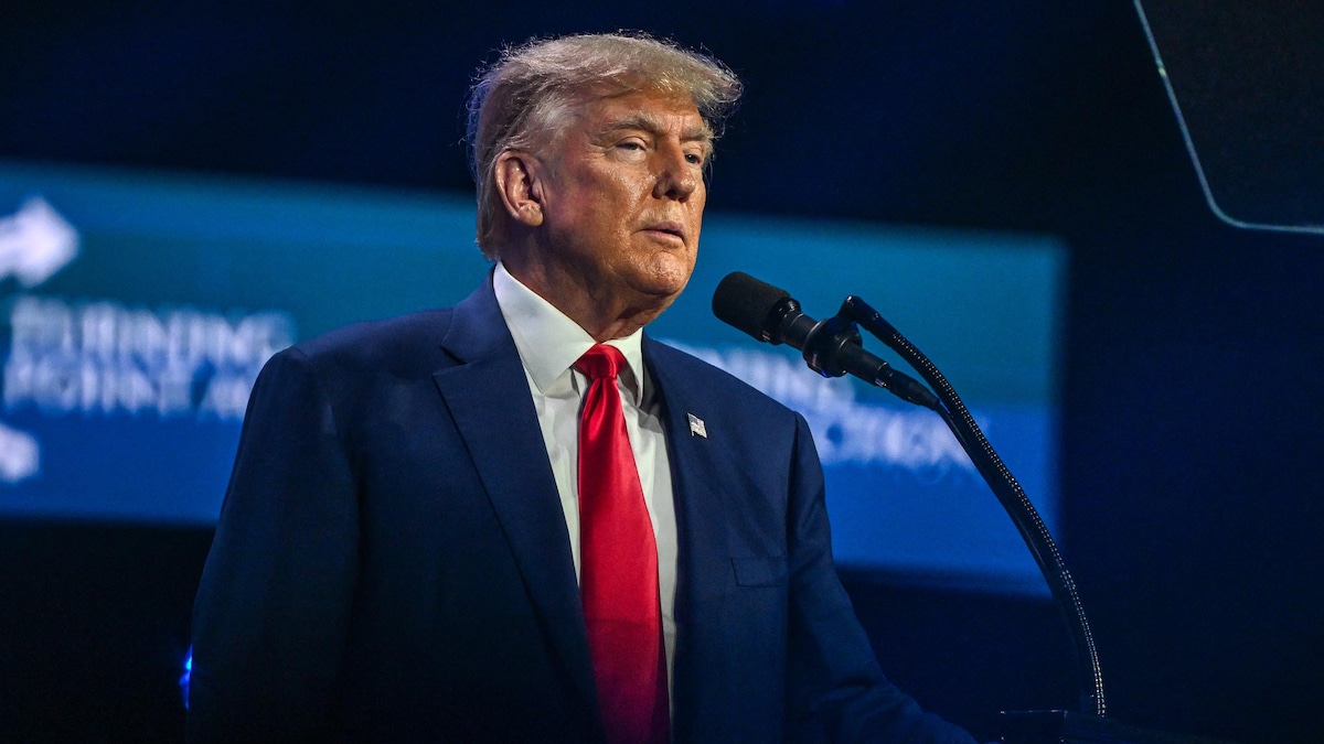 Donald Trump sur une scène devant un micro.