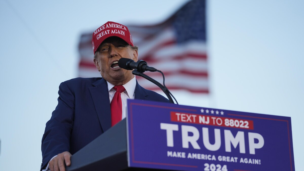 Donald Trump portant une casquette MAGA parle dans un micro.