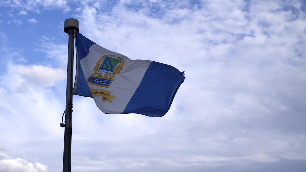 Le drapeau de la police de Trois-Rivières dans un ciel avec quelques nuages.