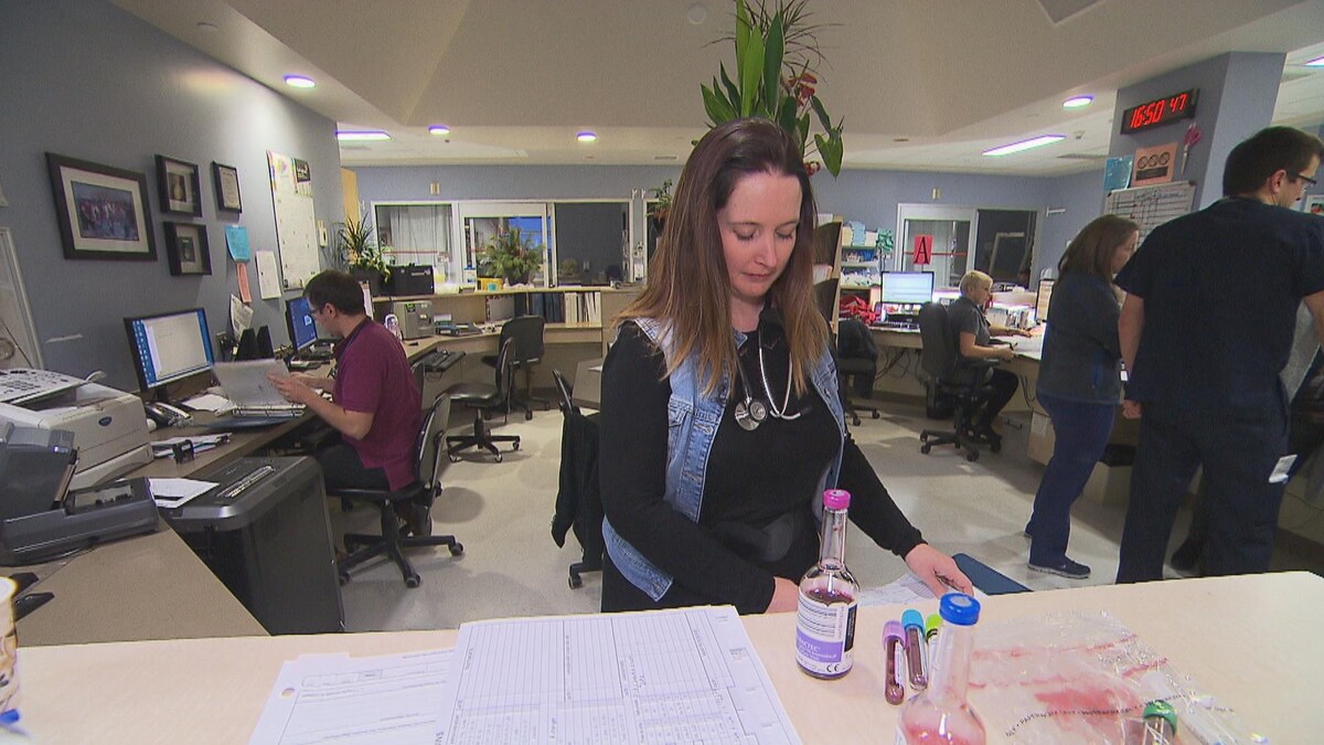 Une femme médecin consulte des dossiers.
