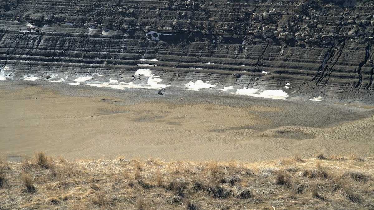 Les berges craquelées du réservoir Oldman où les marques du niveau d'eau sont visibles sur le roc.