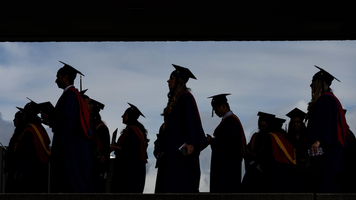 Des silhouettes d'étudiants lors d'une cérémonie de remise de diplômes.