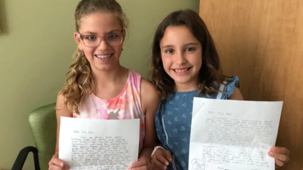 Deux élèves posent fièrement avec leur lettre dans les mains.