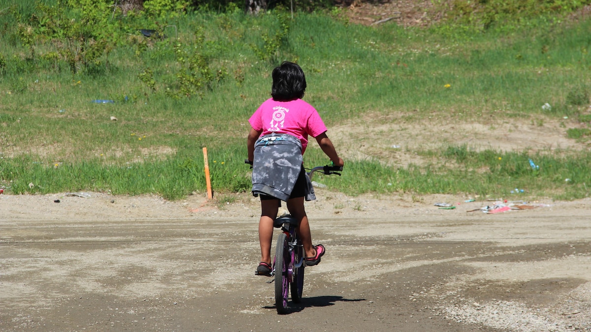 Un enfant sur un vélo de dos.