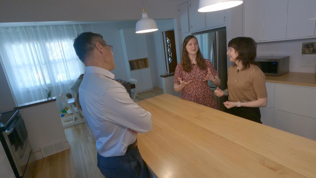 Bruno Savard discute avec deux femmes, dans une cuisine.