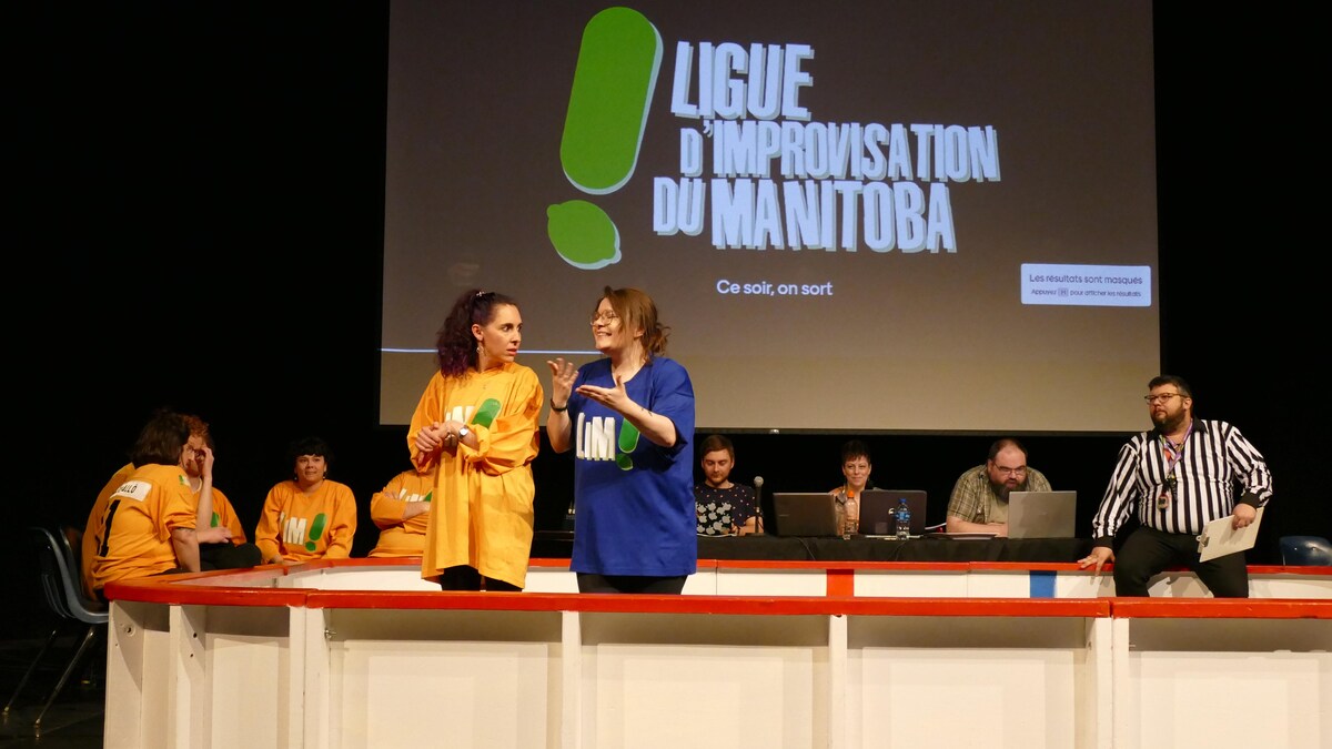 Plusieurs personnes se tiennent dans une salle et jouent un spectacle humoristique. 