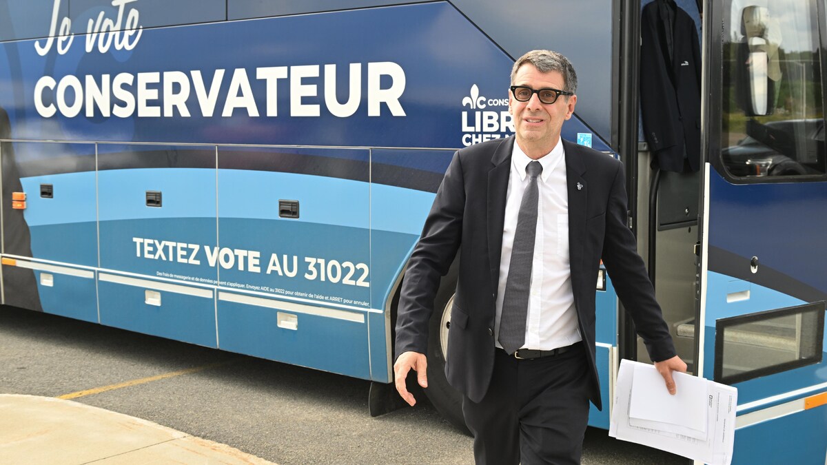 Éric Duhaime devant son autobus de campagne.