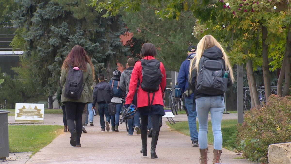 Des étudiants qui marchent vers un bâtiment universitaire à la rentrée.