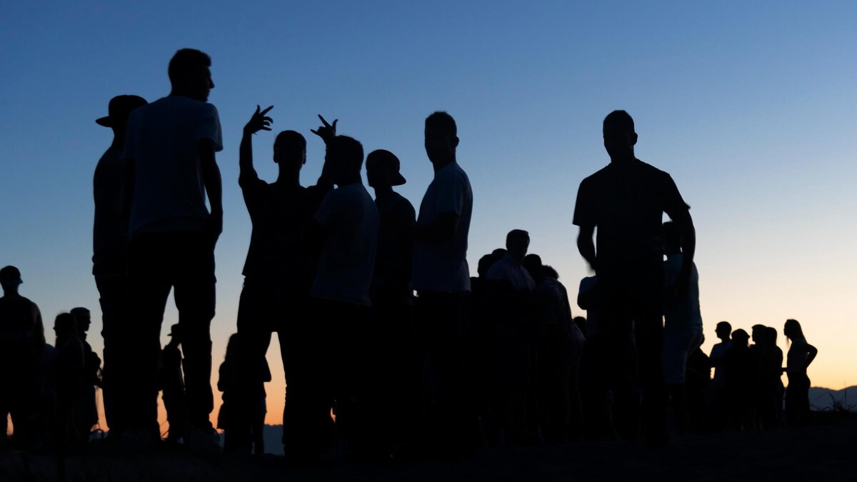 Silhouettes d'adolescents rassemblées au coucher de soleil. 