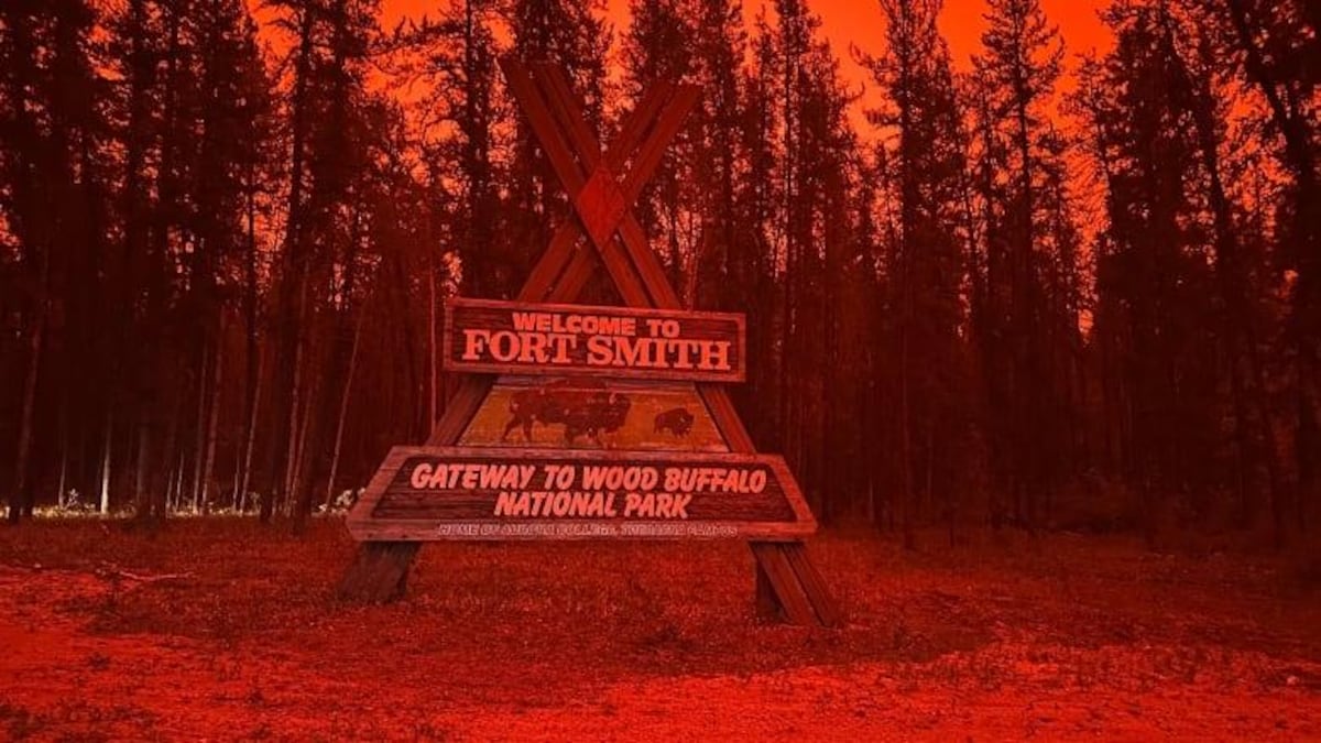Le panneau d'entrée dans la ville de Fort Smith, dans un ciel rouge et enfumé par les feux. 