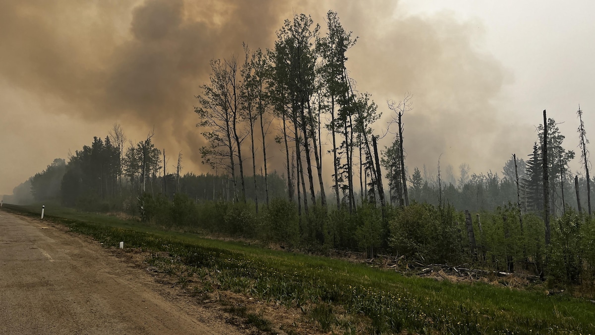 La route 33 près de Swan Hill, avec un feu de forêt et une fumée épaisse, en Alberta, le 21 mai 2023.