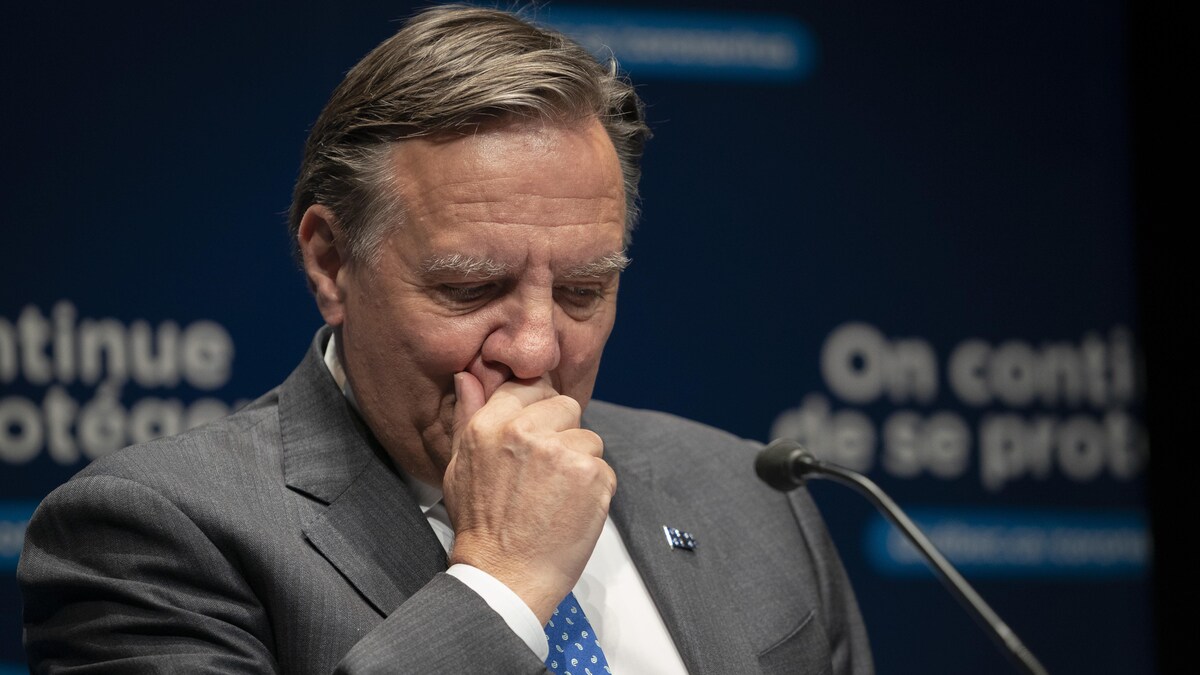 Le premier ministre du Québec, François Legault, avec sa main droite devant sa bouche durant une conférence de presse.
