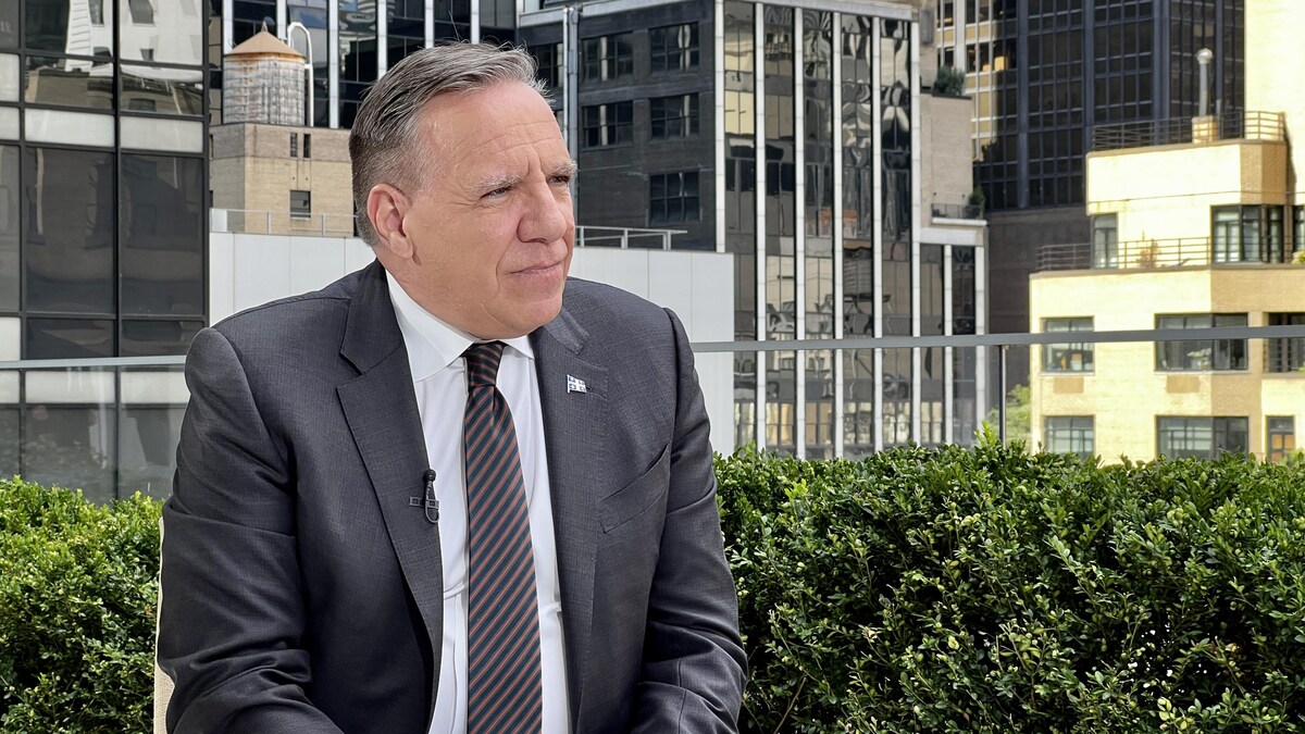 François Legault en entrevue. La ville de New York figure à l'arrière-plan.