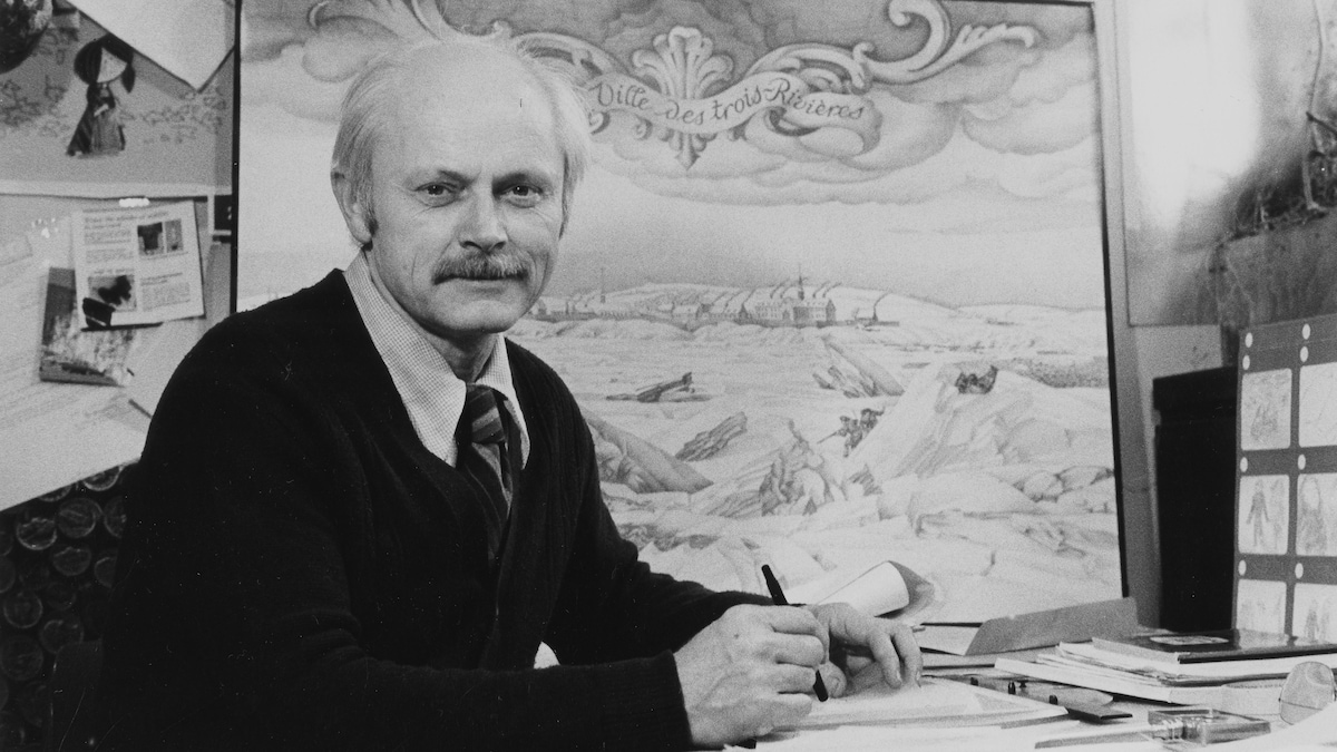 Frédéric Back posant à son bureau tapissé de ses œuvres avec un crayon à la main.