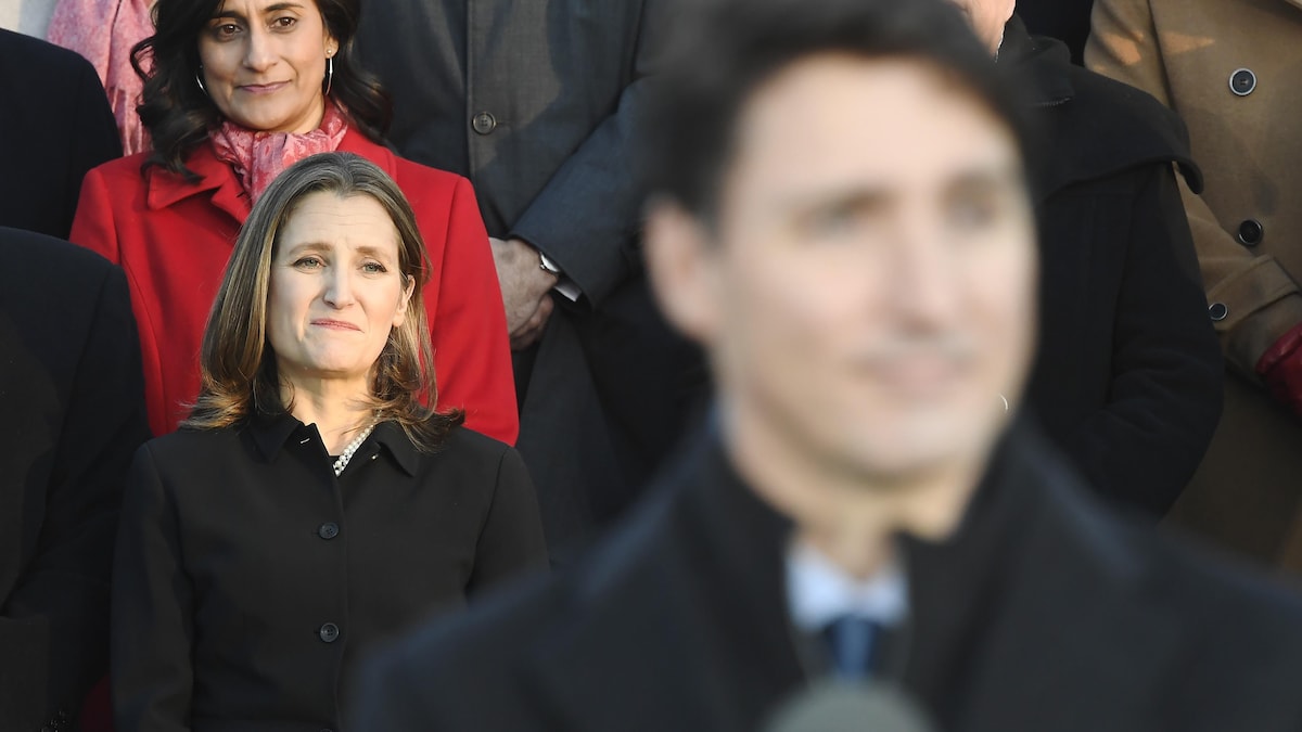 Chrystia Freeland regarde Justin Trudeau parler aux journalistes devant elle.