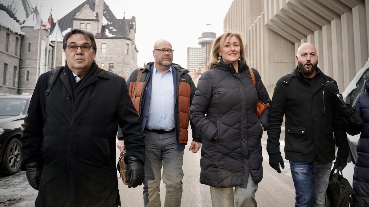 Les quatre dirigeants de syndicats marchent dans une rue de Québec.