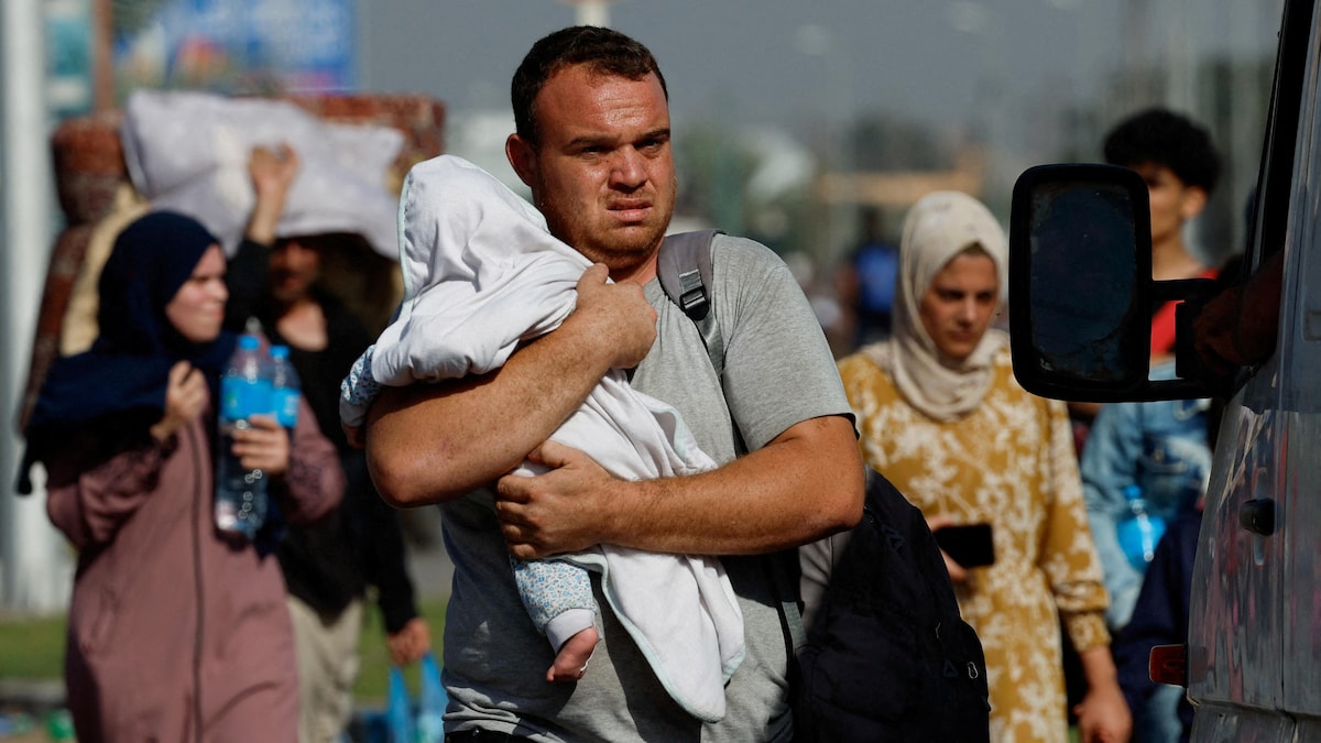 Un homme transporte un enfant et un sac.