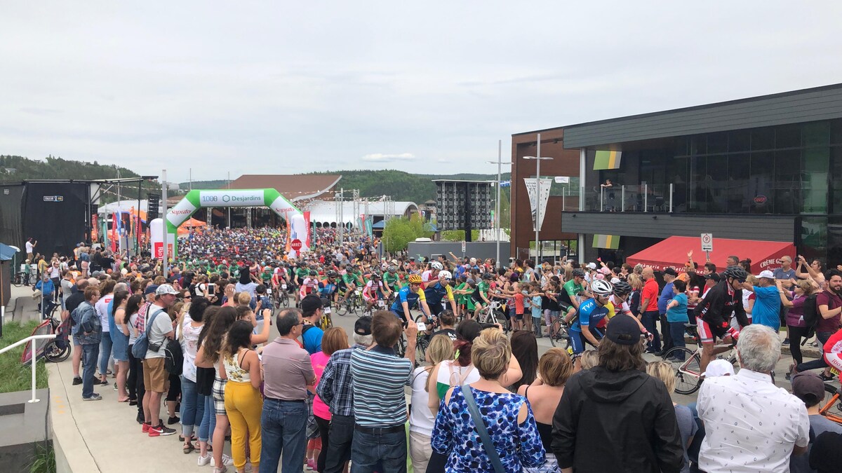 Des cyclistes amorcent le Grand défi Pierre Lavoie sous les regards admiratifs de plusieurs spectateurs. 