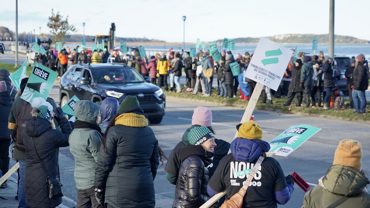 Des personnes manifestents le long du boulevard René-Lepage à Rimouski.      