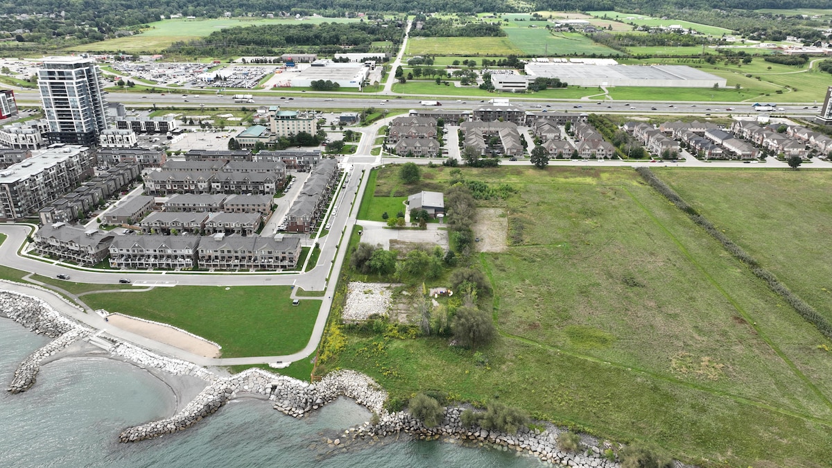 Un grand terrain gazonné près d'un projet immobilier important sur le bord du lac Ontario.