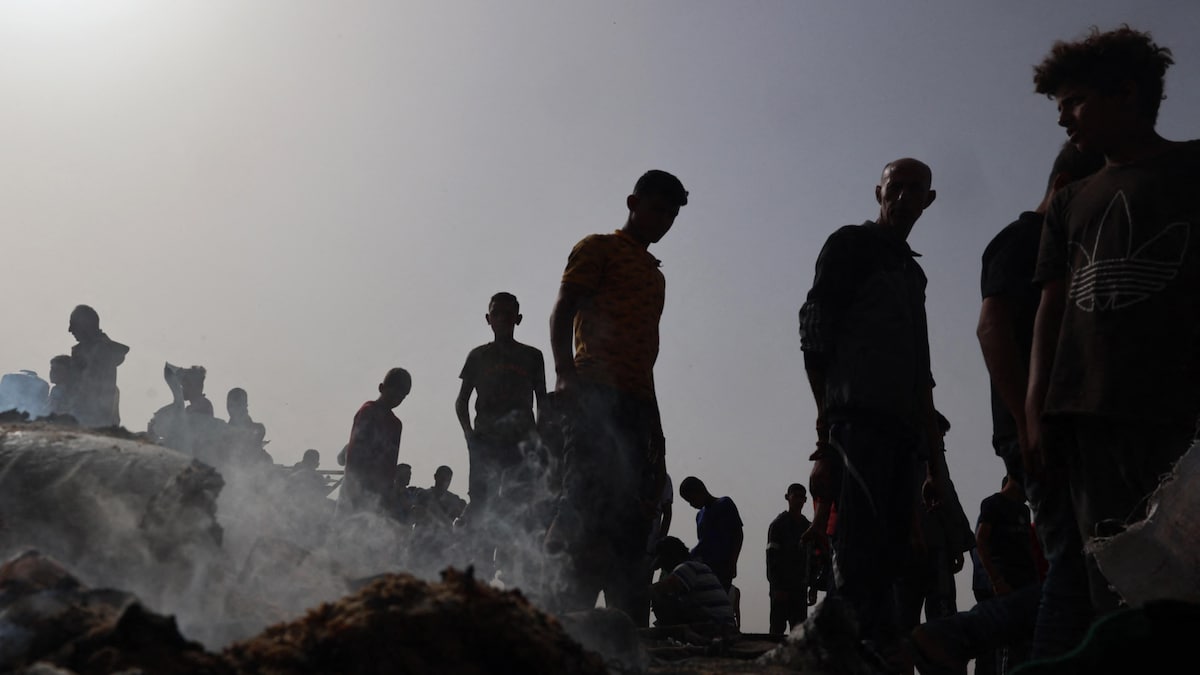 Des Palestiniens autour d'objets encore fumant à la suite d'uen attaque israélienne. 