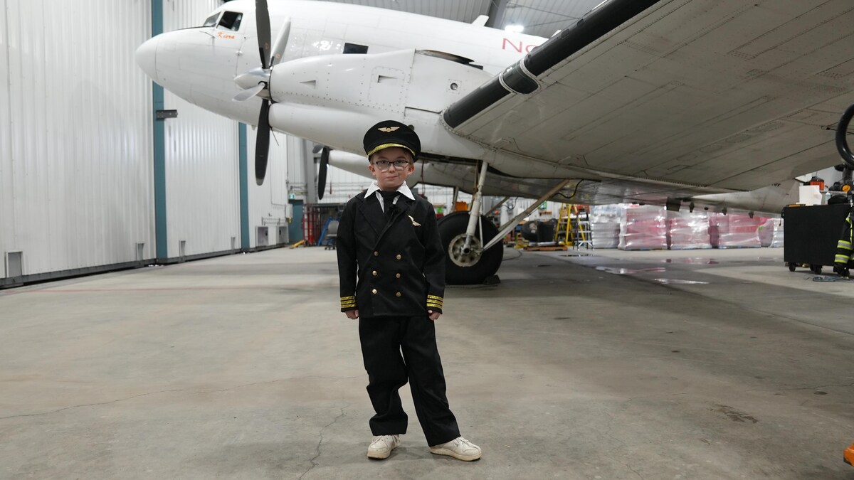 Un jeune homme devant un avion.