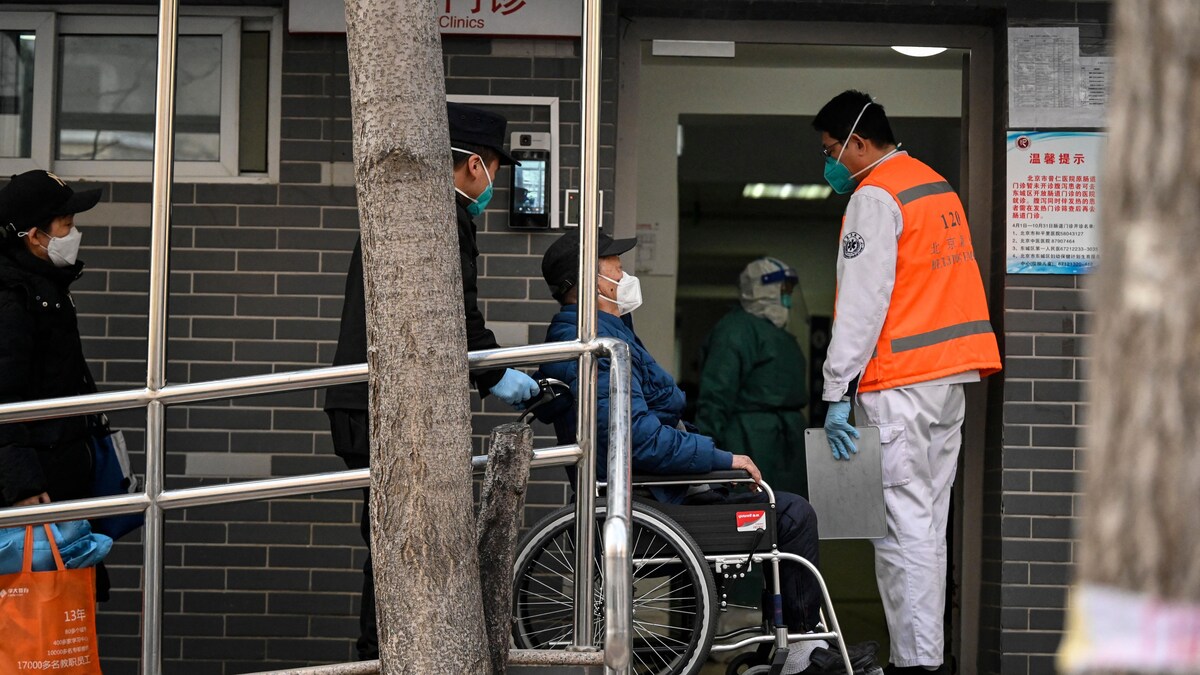 Un homme en fauteuil roulant assisté par des secouristes arrive dans une clinique.