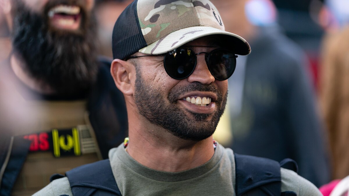 Enrique Tarrio, souriant, porte des lunettes fumées.