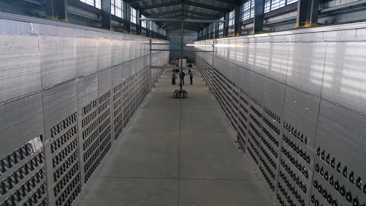 Des centaines d'ordinateurs le long des murs d'un entrepôt.