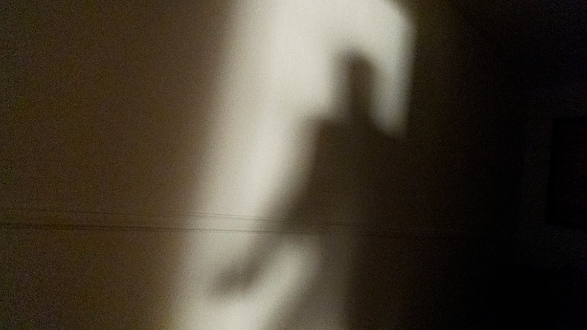 L'ombre d'un homme est projetée sur un mur.