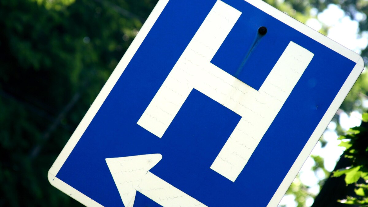 Un panneau de signalisation bleu avec une grosse lettre « H » blanche et une flèche.