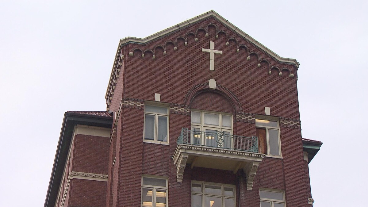 Le haut de l'hôpital Saint-Paul en brique rouge, où l'on voit une croix blanche