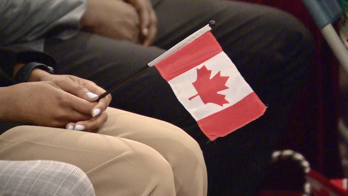 Une personne tient un drapeau du Canada lors d'une cérémonie de citoyenneté à Saskatoon, en Saskatchewan, le 24 mai 2023.