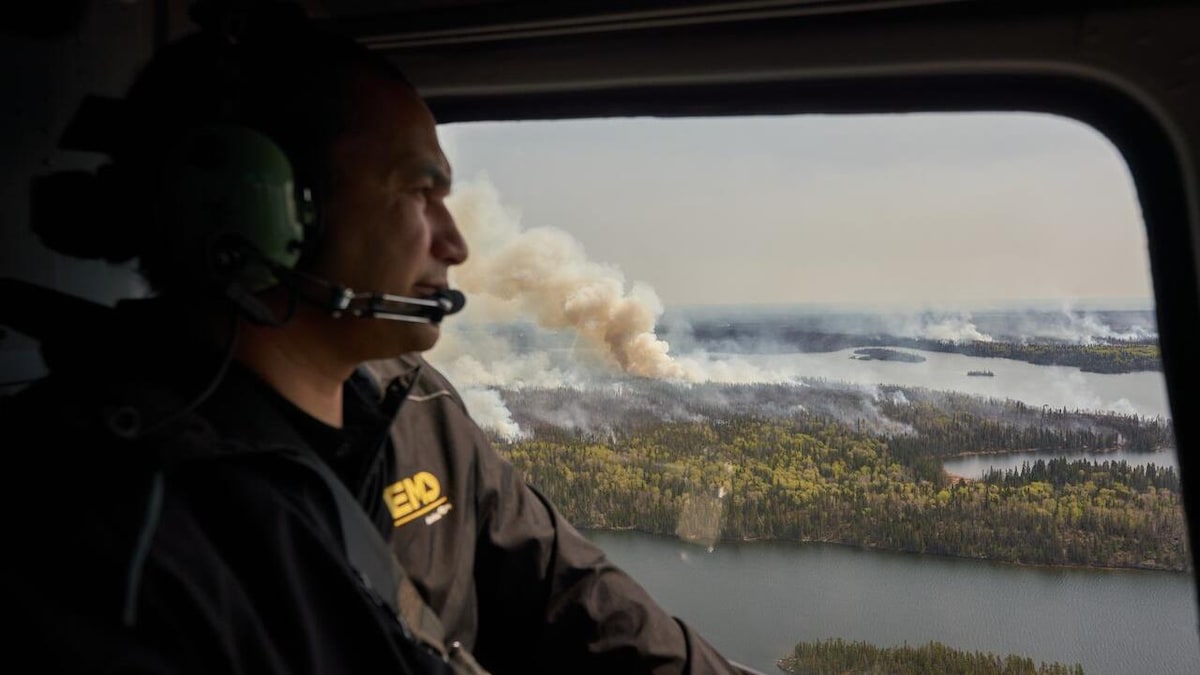 Le premier ministre du Manitoba, Wab Kinew, surveille les feux de forêt qui brûlent dans le nord de la province depuis un hélicoptère, mardi.