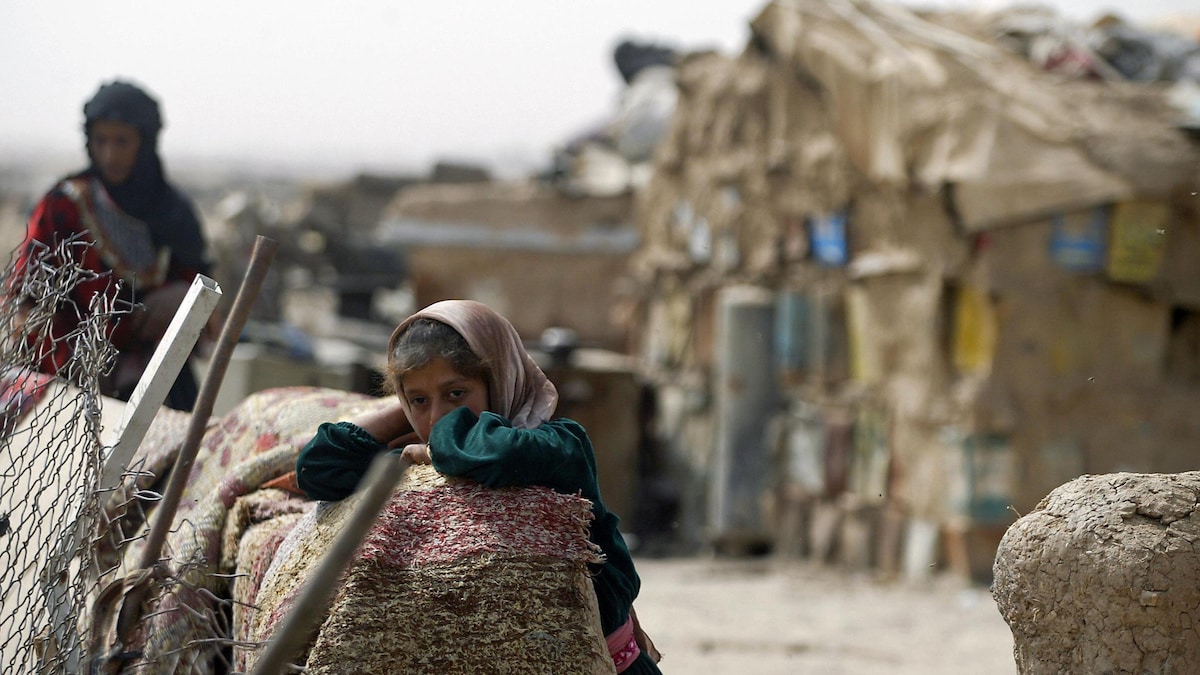 Une jeune fille irakienne se tient devant sa hutte familiale construite près d'un dépotoir dans la périphérie de Bagdad.
