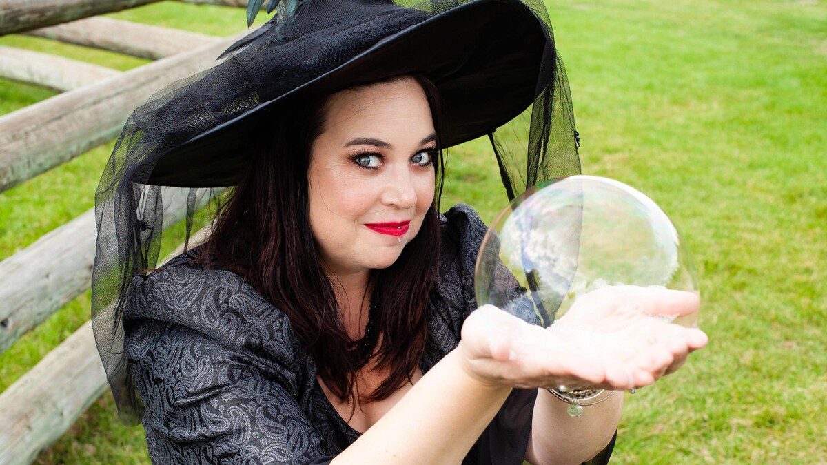 Isabelle Cliche est déguisée en sorcière et et montre dans ses mains, une grosse bulle de savon.