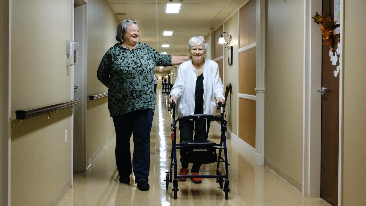Isabelle Morasse et Rollande Camirand marchent dans un couloir d'une résidence pour aînés.