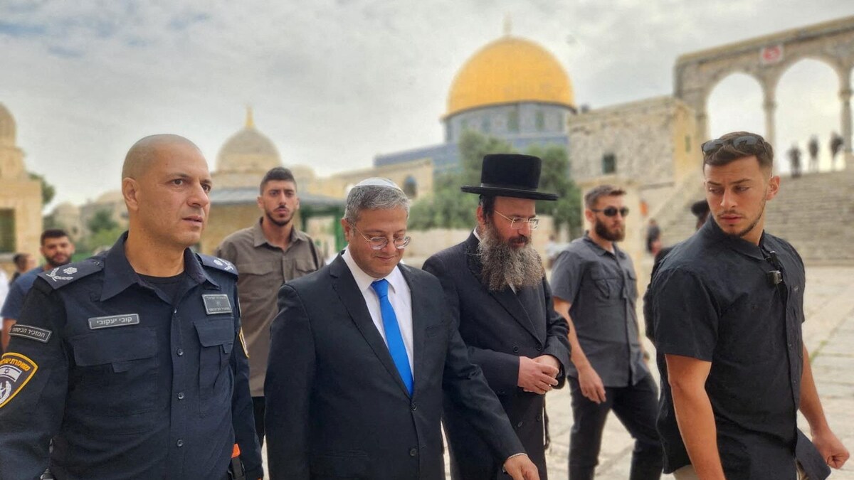 Un homme marche entouré d'un policier et d'un rabbin.