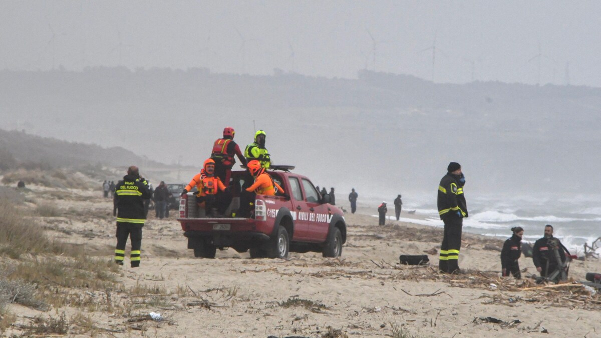 Des sauveteurs travaillent sur une plage en Italie à la suite de l'écrasement d'une embarcation sur les rochers.