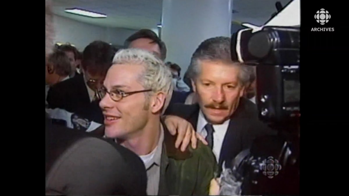 Jacques Villeneuve se frayant un chemin parmi la foule et les médias à l'aéroport.