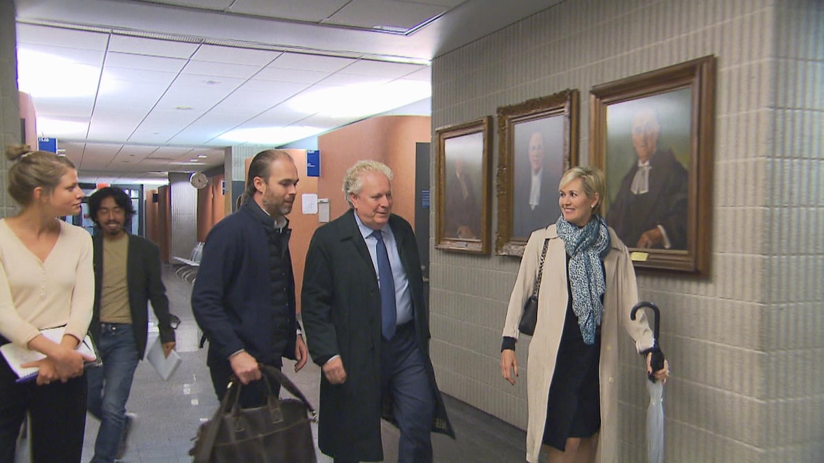 Jean Charest marche dans un couloir du palais de justice de Montréal.