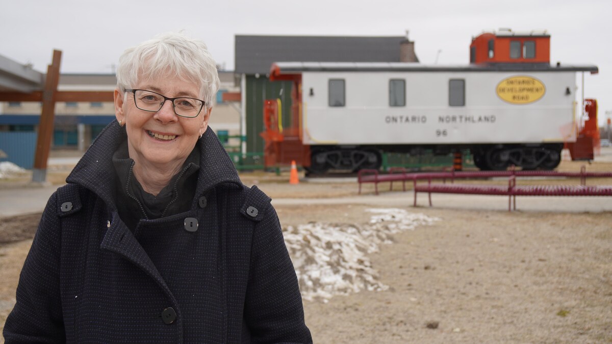 Une femme devant une locomotive.