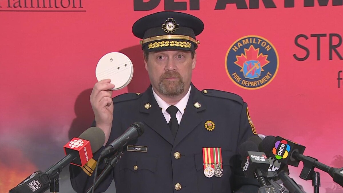 Le commissaire des incendies de l'Ontario, Jon Pegg, tient un détecteur de fumée dans sa main lors d'une conférence de presse.
